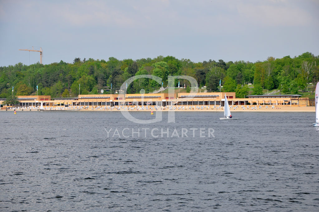 Der Große Wannsee ist einer der größten Havelseen im Berliner Stadtgebiet. Bekannt geworden ist er vor allem duchrch sein Strandbad und dessen Beliebtheit bei den Berlinern. Zwischen vielen Seglern und Fahrgastschiffen erreichen wir die Havel (UHW km 12) und steuern nach Backbord. Auf dem Weg zurück nach Potsdam lassen wir die Pfaueninsel links liegen. Mit ihrem als Ruine erbauten Schloss ist sie ein beliebtes Ausflugsziel, vor allem für Familien. Kurz darauffahren wir in den Jungfernsee ein. An Steuerbord sehen wir am Sacrower Ufer die Heilandskiche, in der gelegentlich Sportschiffer-Gottesdienste abgehalten werden.